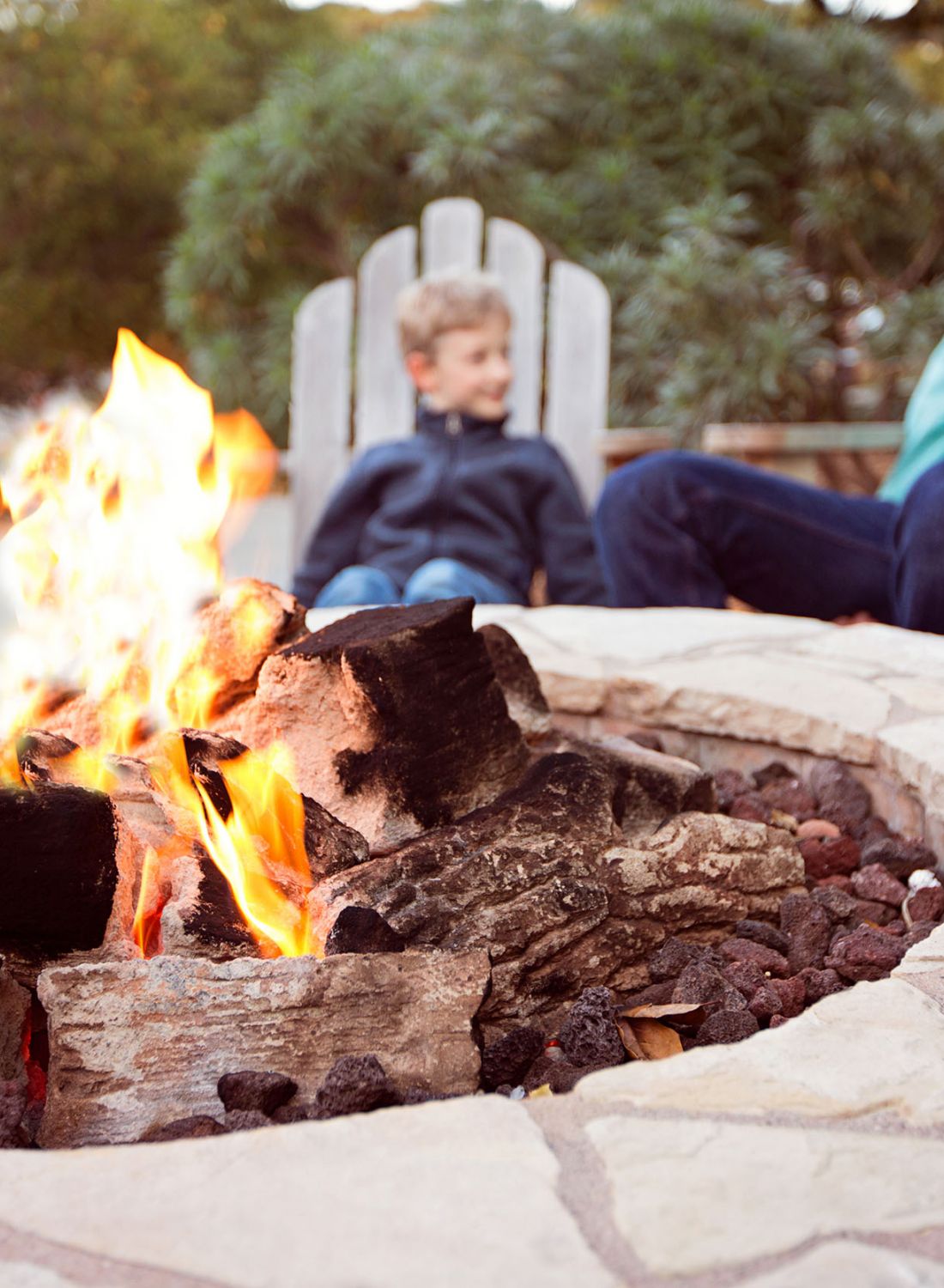 Fire pit with father and son enjoying time together in chairs in the background