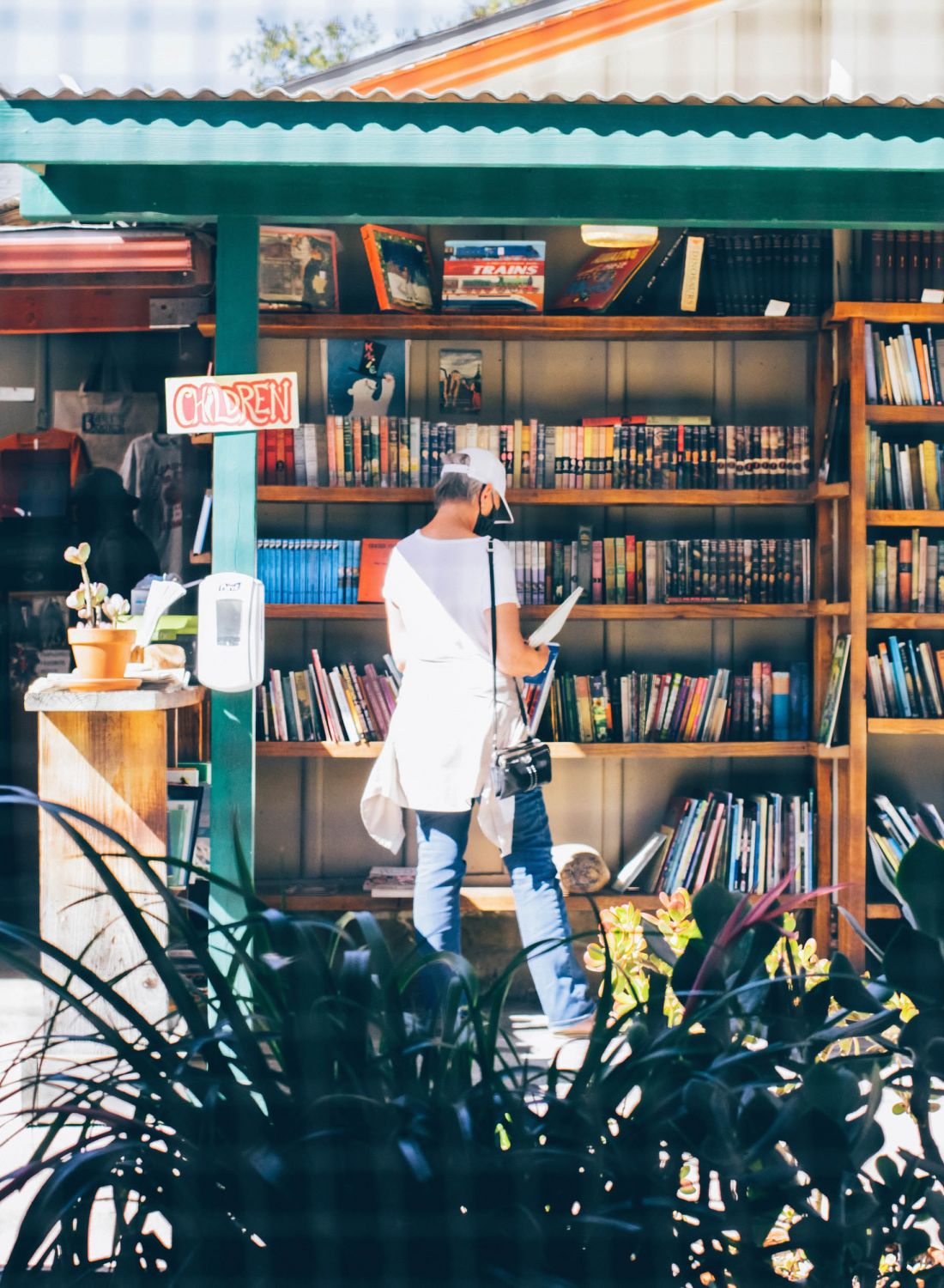 Woman reading a book in front of outdoor book store.